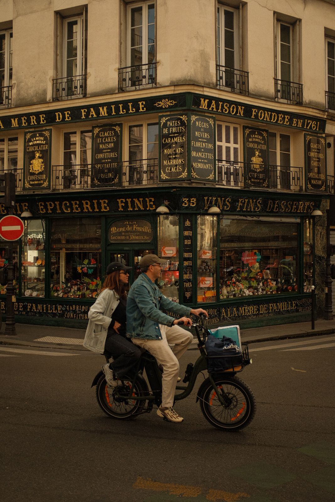 A couple on a scooter outside À la Mère de Famille in Paris
