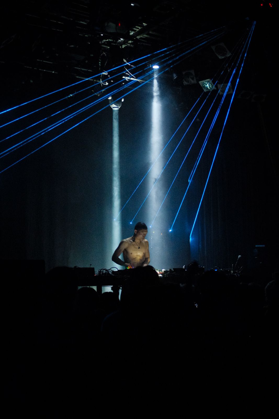 A DJ under laser beams in the dark