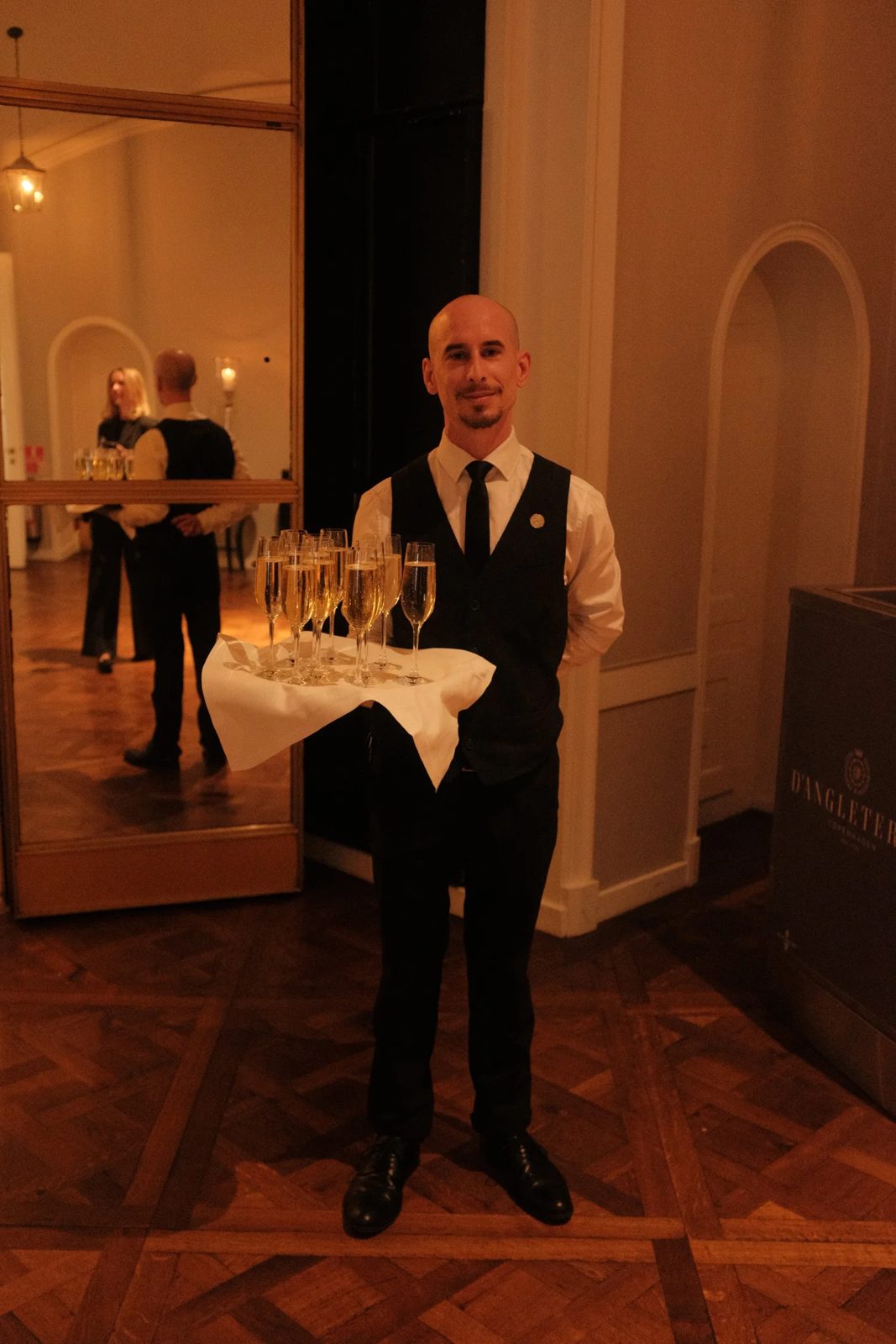 A waiter with a tray of champagne at the reception